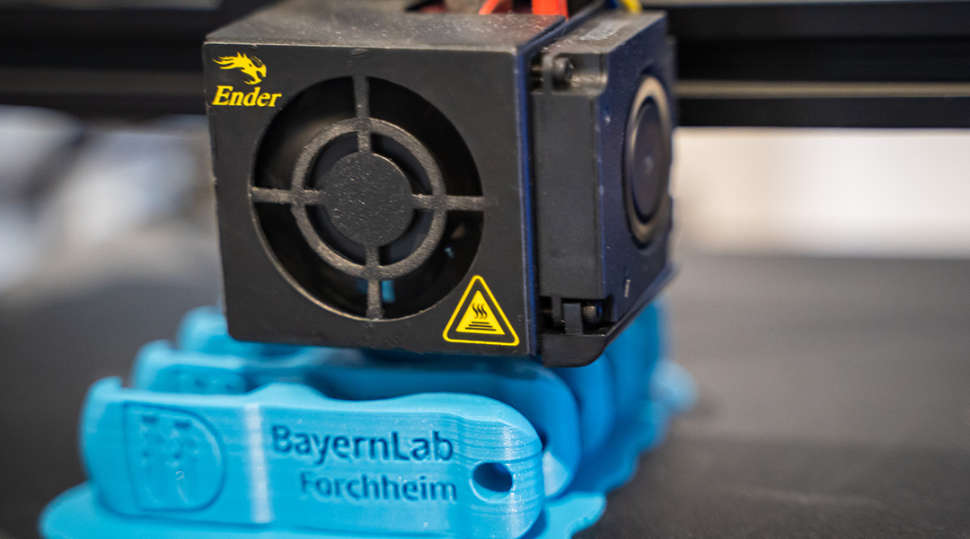 Der 3D-Drucker im BayernLab Forchheim druck Flaschenöffner mit der Aufschrift 